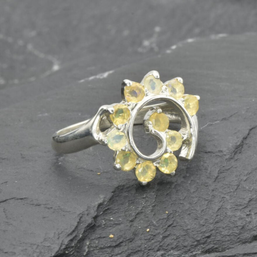 Opal Spiral Ring in sterling silver designed as a sunburst swirl statement jewelry piece offering radiant flashes of fire colors and boho charm, believed to inspire creativity and positivity, making it a thoughtful October birthstone gift idea. Perfect to wear at weddings, parties, and special occasions for a vibrant standout look.