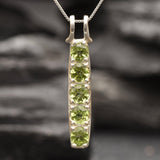 Natural peridot stones arranged in a vertical pendant, suspended from a complimentary sterling silver chain, ideal for adding vibrant green hues to your jewelry collection.