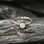 White Opal bezel solitaire ring with round cut stone and twisted band in sterling silver, a timeless jewelry style that highlights flashes of fire colors and durability. Offers the benefit of a secure bezel setting with a refined solitaire look, making it a meaningful October birthstone gift idea. Perfect for birthdays, anniversaries, engagements, and daily wear events.