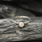 White Opal bezel solitaire ring with round cut stone and twisted band in sterling silver, a timeless jewelry style that highlights flashes of fire colors and durability. Offers the benefit of a secure bezel setting with a refined solitaire look, making it a meaningful October birthstone gift idea. Perfect for birthdays, anniversaries, engagements, and daily wear events.