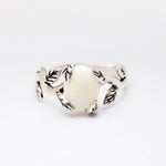 White Opal cabochon vine and leaf ring crafted in solid 925 sterling silver, featuring a nature-inspired design with flashes of fire colors. The durable vine-style band offers elegance and uniqueness while remaining comfortable for daily wear. As the October Birthstone, White Opal makes a thoughtful gift for birthdays, anniversaries, and nature lovers. Perfect to wear at weddings, outdoor celebrations, and festive gatherings.