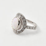 Natural Australian Opal sterling silver halo ring with an oval cabochon cut gemstone encircled by sparkling CZ Diamonds, offering a refined and timeless style. Opal, the October birthstone, is cherished for enhancing creativity and emotional balance, making it a meaningful gift for birthdays, anniversaries, engagements, weddings, and milestone celebrations.