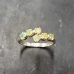 Ethiopian Opal Bypass Ring in silver with six cabochon stones aligned in a curved wrap setting, a stylish jewelry design that radiates flashes of fire colors and adds a modern edge, making it a thoughtful October birthstone gift idea. Perfect to wear at weddings, cocktail parties, and romantic dinners for a bold yet refined look.