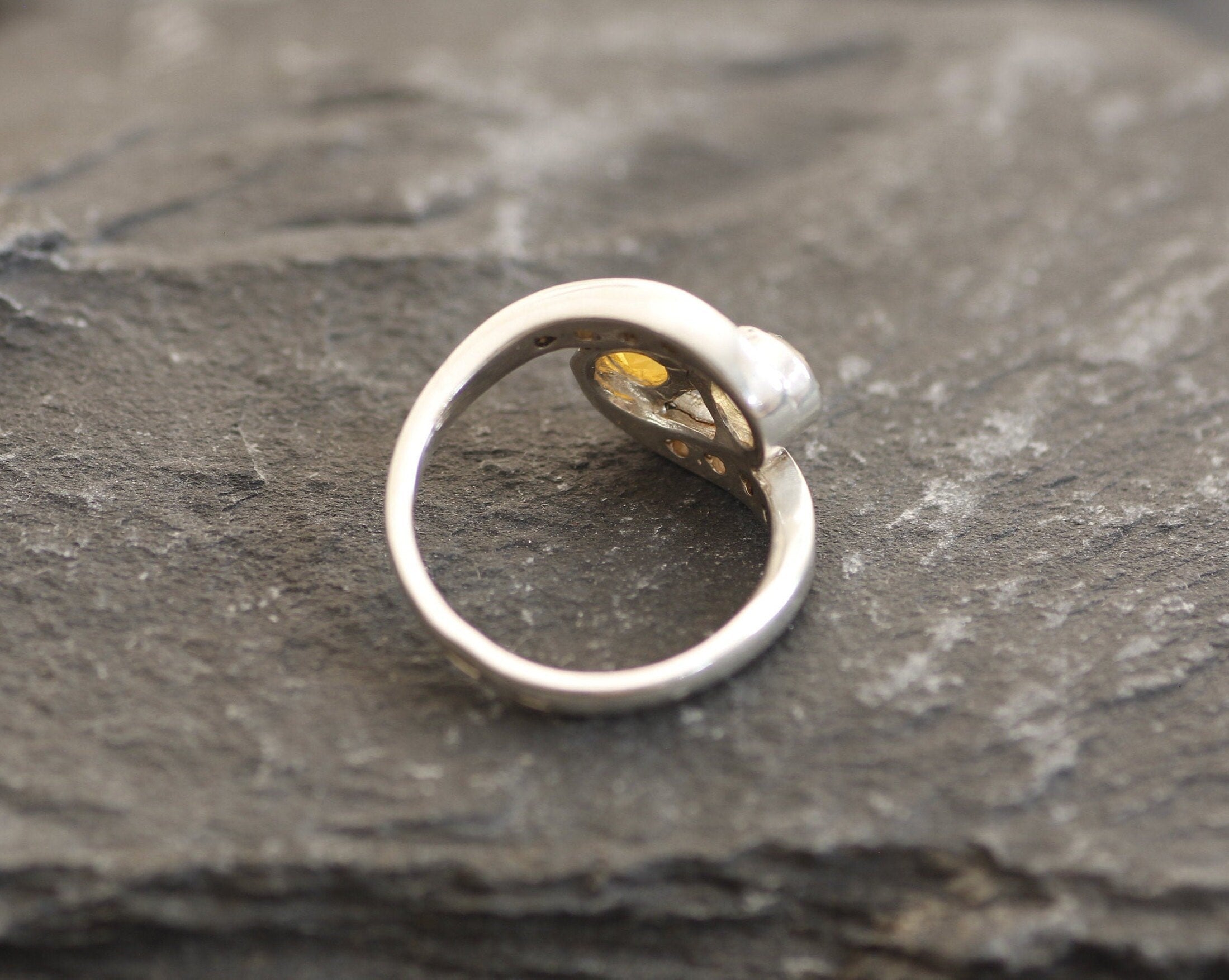 Two-Stone Opal Bypass Wave Ring in sterling silver showcasing cabochon-cut opals with flashes of fire colors and CZ pave accents for an elegant jewelry style. Known for enhancing emotional clarity and balance, this October birthstone ring makes a thoughtful and meaningful gift idea. Perfect for anniversaries, weddings, cocktail events, and celebratory occasions where sophistication shines.