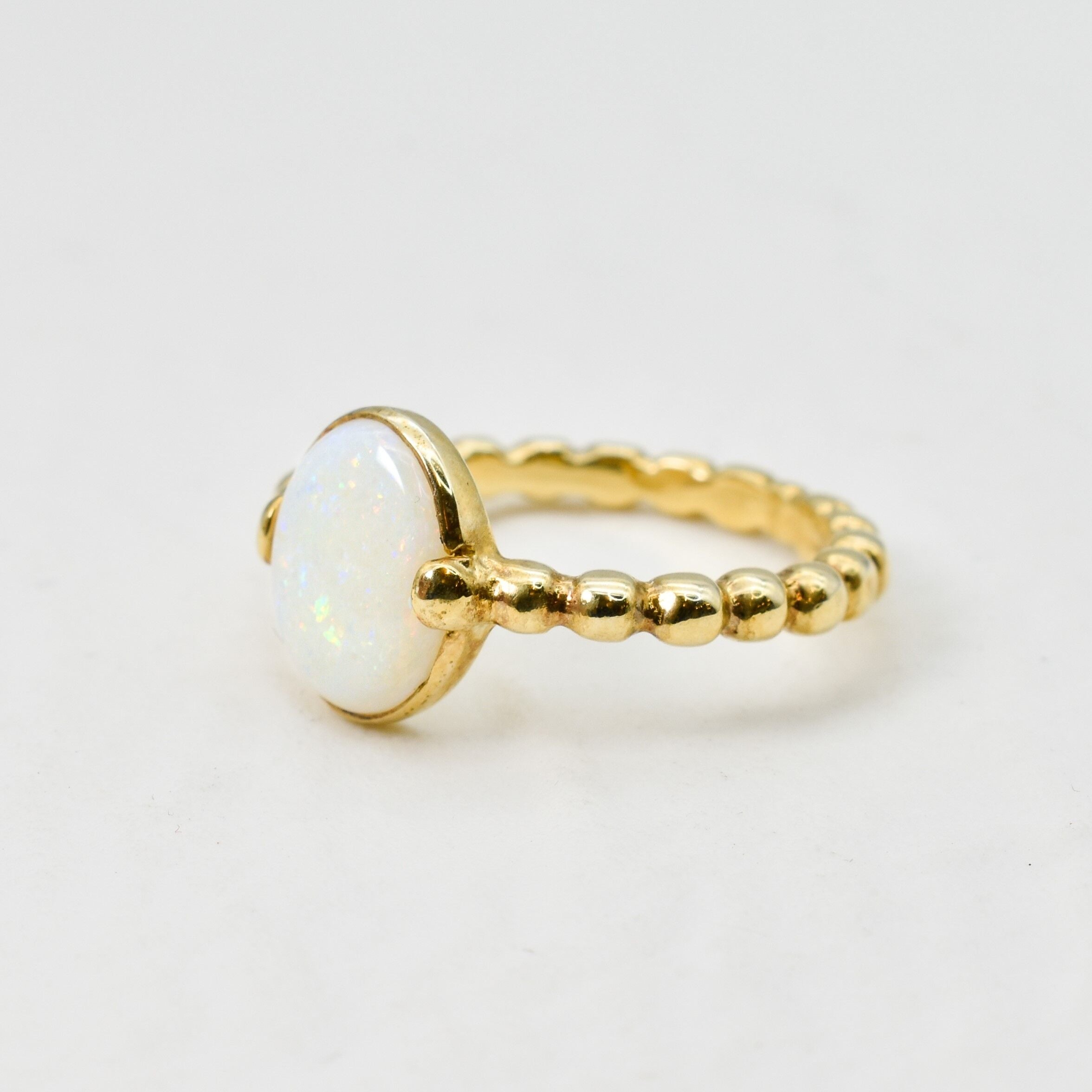 Natural Opal beaded gold ring with a smooth cabochon cut gemstone, offering a minimalist yet elegant style perfect for everyday wear. Opal, the October birthstone, is believed to inspire creativity and emotional balance, making it a meaningful gift for birthdays, anniversaries, weddings, and milestone celebrations.