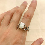 White Opal Leaf Ring styled on the index finger with nude nails, sterling silver vine band highlighting the stone’s play of fire. A meaningful October Birthstone gift ideal for anniversaries, art shows, and romantic dinners.