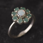 Opal and Emerald Flower Ring in sterling silver with a floral cluster design showing flashes of fire colors from the opal and genuine green emeralds. Opal is the October birthstone linked to inspiration and creativity, while emerald is the May birthstone symbolizing love and harmony, making this a meaningful birthstone gift. A thoughtful present for birthdays, anniversaries, and special occasions. Suitable for daily wear, weddings, dinners, and parties.