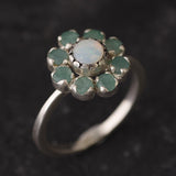 Opal and Emerald Flower Ring in sterling silver with a floral cluster design showing flashes of fire colors from the opal and genuine green emeralds. Opal is the October birthstone linked to inspiration and creativity, while emerald is the May birthstone symbolizing love and harmony, making this a meaningful birthstone gift. A thoughtful present for birthdays, anniversaries, and special occasions. Suitable for daily wear, weddings, dinners, and parties.