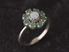 Opal and Emerald Flower Ring in sterling silver with a floral cluster design showing flashes of fire colors from the opal and genuine green emeralds. Opal is the October birthstone linked to inspiration and creativity, while emerald is the May birthstone symbolizing love and harmony, making this a meaningful birthstone gift. A thoughtful present for birthdays, anniversaries, and special occasions. Suitable for daily wear, weddings, dinners, and parties.