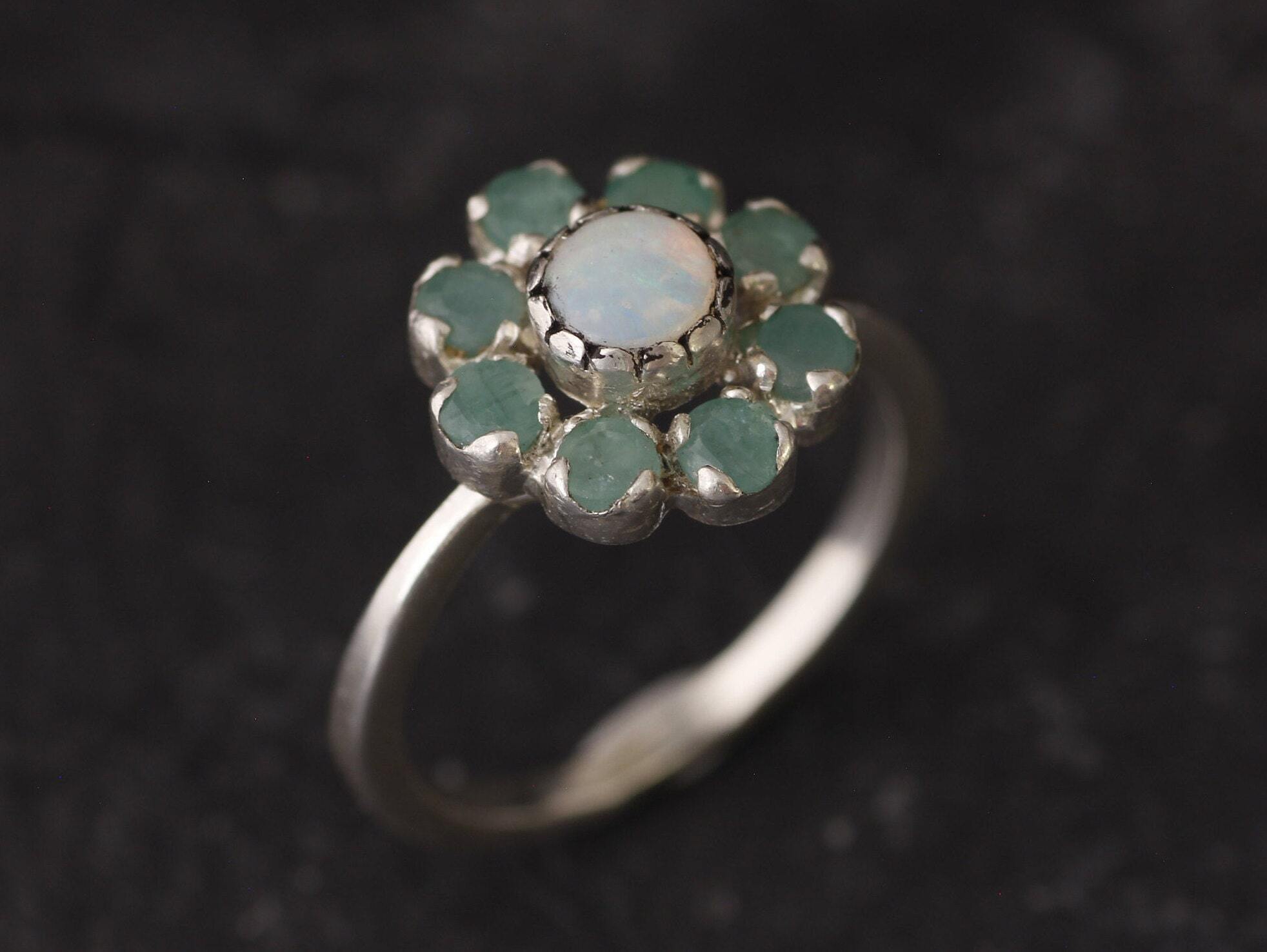 Opal and Emerald Flower Ring in sterling silver with a floral cluster design showing flashes of fire colors from the opal and genuine green emeralds. Opal is the October birthstone linked to inspiration and creativity, while emerald is the May birthstone symbolizing love and harmony, making this a meaningful birthstone gift. A thoughtful present for birthdays, anniversaries, and special occasions. Suitable for daily wear, weddings, dinners, and parties.