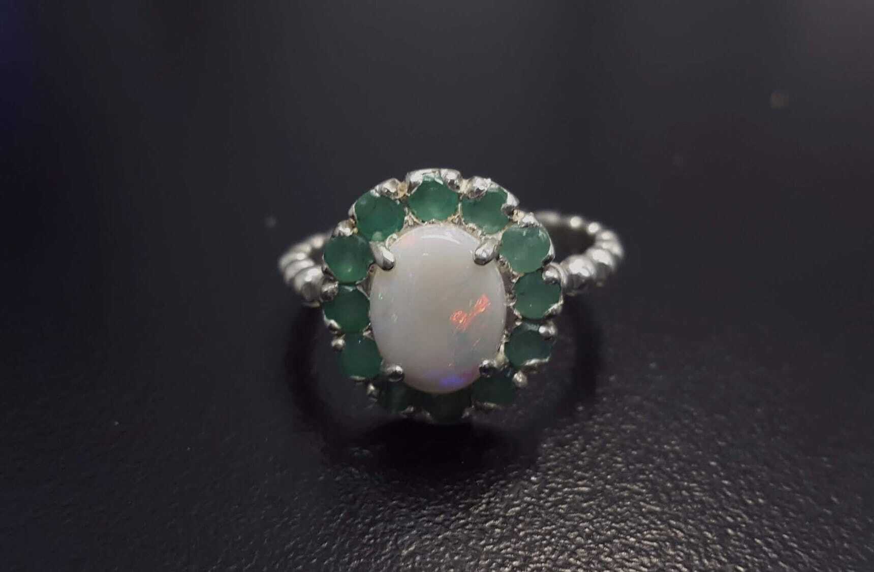 Opal halo floral ring with Genuine Emeralds in a vintage victorian flower halo, White cabochon center, and beaded Bubble Band for a bold statement cocktail look showing flashes of fire colors. Benefits include creativity, harmony, and calm. Ideal October birthstone gift with meaningful May emerald accents.
Worn for weddings, cocktail parties, anniversaries, graduations, garden events, and holiday gatherings.