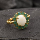 Opal halo floral ring with Genuine Emeralds in a vintage victorian flower halo, White cabochon center, and beaded Bubble Band for a bold statement cocktail look showing flashes of fire colors. Benefits include creativity, harmony, and calm. Ideal October birthstone gift with meaningful May emerald accents.
Worn for weddings, cocktail parties, anniversaries, graduations, garden events, and holiday gatherings.