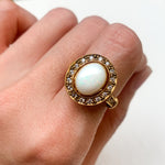 Natural Opal ring in gold with a halo of sparkling diamonds, featuring a cabochon cut gemstone for an elegant and timeless style. Known for promoting creativity and emotional balance, Opal is the October birthstone and makes a thoughtful gift for birthdays, anniversaries, weddings, or milestone celebrations.