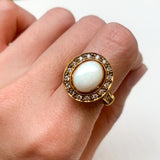 Natural Opal ring in gold with a halo of sparkling diamonds, featuring a cabochon cut gemstone for an elegant and timeless style. Known for promoting creativity and emotional balance, Opal is the October birthstone and makes a thoughtful gift for birthdays, anniversaries, weddings, or milestone celebrations.