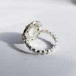 White Opal flower cluster ring in sterling silver with colorful Amethyst and Peridot halo in a cocktail style. The elegant cluster design adds sparkle. Opal is linked with hope and clarity, Amethyst with calm, Peridot with fresh energy. A lovely birthstone gift for October, February and August. Wear to weddings, graduations, dinner dates and holiday parties.