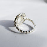 White Opal flower cluster ring in sterling silver with colorful Amethyst and Peridot halo in a cocktail style. The elegant cluster design adds sparkle. Opal is linked with hope and clarity, Amethyst with calm, Peridot with fresh energy. A lovely birthstone gift for October, February and August. Wear to weddings, graduations, dinner dates and holiday parties.