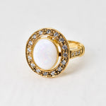 Natural Opal ring in gold with a halo of sparkling diamonds, featuring a cabochon cut gemstone for an elegant and timeless style. Known for promoting creativity and emotional balance, Opal is the October birthstone and makes a thoughtful gift for birthdays, anniversaries, weddings, or milestone celebrations.