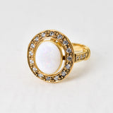 Natural Opal ring in gold with a halo of sparkling diamonds, featuring a cabochon cut gemstone for an elegant and timeless style. Known for promoting creativity and emotional balance, Opal is the October birthstone and makes a thoughtful gift for birthdays, anniversaries, weddings, or milestone celebrations.