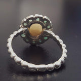 Opal halo floral ring with Genuine Emeralds in a vintage victorian flower halo, White cabochon center, and beaded Bubble Band for a bold statement cocktail look showing flashes of fire colors. Benefits include creativity, harmony, and calm. Ideal October birthstone gift with meaningful May emerald accents.
Worn for weddings, cocktail parties, anniversaries, graduations, garden events, and holiday gatherings.