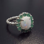 Opal halo floral ring with Genuine Emeralds in a vintage victorian flower halo, White cabochon center, and beaded Bubble Band for a bold statement cocktail look showing flashes of fire colors. Benefits include creativity, harmony, and calm. Ideal October birthstone gift with meaningful May emerald accents.
Worn for weddings, cocktail parties, anniversaries, graduations, garden events, and holiday gatherings.
