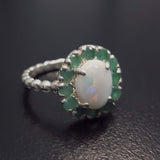 Opal halo floral ring with Genuine Emeralds in a vintage victorian flower halo, White cabochon center, and beaded Bubble Band for a bold statement cocktail look showing flashes of fire colors. Benefits include creativity, harmony, and calm. Ideal October birthstone gift with meaningful May emerald accents.
Worn for weddings, cocktail parties, anniversaries, graduations, garden events, and holiday gatherings.