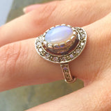 Natural Australian Opal halo sterling silver ring worn on the hand in natural daylight, adding elegance to both casual and formal looks, perfect for October birthstone gifting, weddings, or romantic dinners.