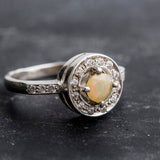 Ethiopian Opal diamond cut halo ring in solid 925 sterling silver, surrounded by sparkling CZ accents for brilliance and elegance. The halo design highlights flashes of fire colors while offering timeless durability. As the October Birthstone, Opal makes a meaningful gift for birthdays, engagements, anniversaries, or personal milestones. Perfect to wear at weddings, cocktail parties, and festive gatherings.