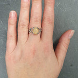 Flower Opal Ring styled on the index finger with nude nails, a vine and branch detail that enhances personal expression, offering positivity as an October birthstone gift, great for weddings and anniversary dinners.