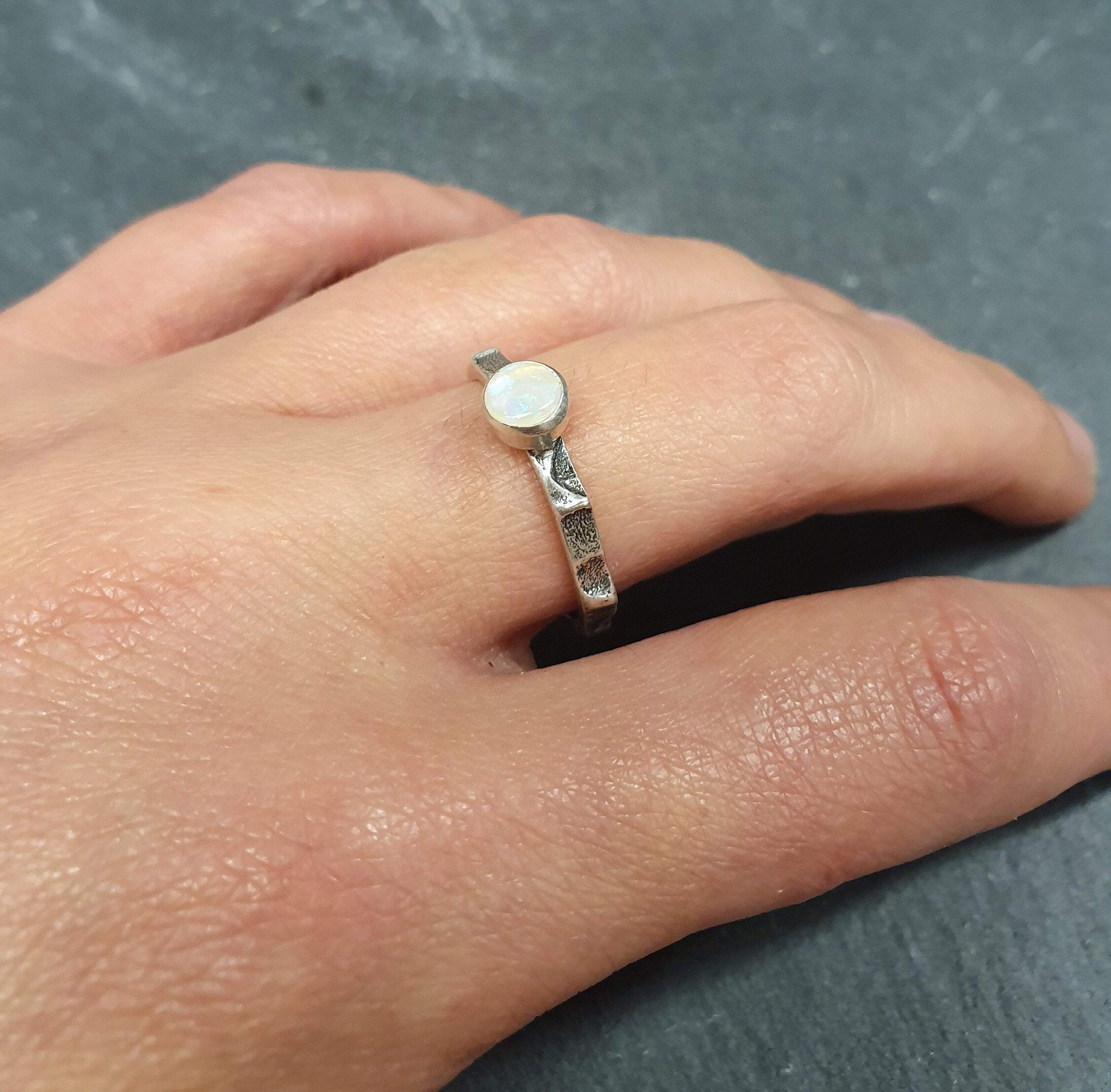 Bezel Opal Ring worn on middle finger with bare nails and silver textured band. Perfect for enhancing inspiration and emotional balance, making it a thoughtful October birthstone gift. Ideal for casual outings, friendly gatherings and everyday wear.