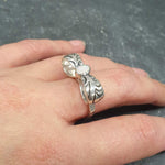 Opal ring in handcrafted solid silver with a ribbon bow style band and white cabochon showing flashes of fire color, a statement design that brightens the hand. Brings creative spark and calm confidence while adding a luminous white accent to any look. A thoughtful October birthstone gift idea for someone special.
Wear to weddings, anniversaries, engagements, date nights, office parties, graduations, and holiday gatherings.