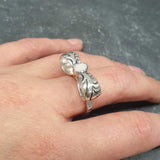 Opal ring in handcrafted solid silver with a ribbon bow style band and white cabochon showing flashes of fire color, a statement design that brightens the hand. Brings creative spark and calm confidence while adding a luminous white accent to any look. A thoughtful October birthstone gift idea for someone special.
Wear to weddings, anniversaries, engagements, date nights, office parties, graduations, and holiday gatherings.