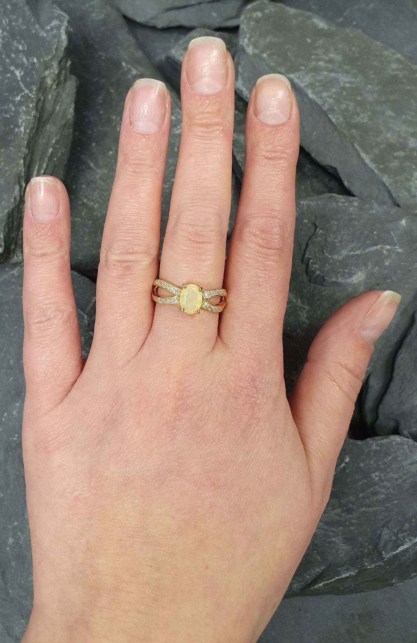 Opal Ring styled on a bare hand with minimal accessories, featuring a split shank band and CZ pave sparkle. Enhances positivity and inspiration, making it an ideal October birthstone present. Suitable for work meetings, cocktail parties, and weekend gatherings.