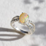 Opal Ring with split shank band and CZ pave setting showing flashes of fire colors, designed as elegant fine jewelry. Known for its emotional healing and creativity benefits, Opal is also the October birthstone and a thoughtful gift for birthdays or anniversaries. Perfect to wear at weddings, romantic dinners, and special evening celebrations.
