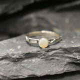 Opal Ring in sterling silver with a hammered textured band and bezel set white opal that shows flashes of fire colors. Opal is linked to creativity, inspiration and emotional balance, making it a meaningful October birthstone gift. A perfect present for birthdays, anniversaries or promise rings. Suitable for daily wear, weddings, parties and special occasions.