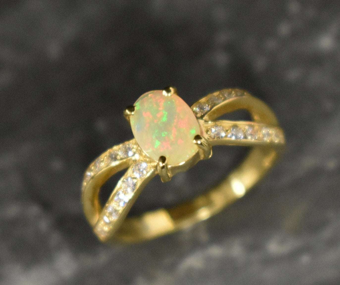 Opal Ring with split shank band and CZ pave setting showing flashes of fire colors, designed as elegant fine jewelry. Known for its emotional healing and creativity benefits, Opal is also the October birthstone and a thoughtful gift for birthdays or anniversaries. Perfect to wear at weddings, romantic dinners, and special evening celebrations.