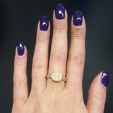 Horizontal Oval Ethiopian Fire Opal Ring in sterling silver worn on middle finger with natural nails. The opal’s flashes of fire colors create an elegant shimmer, while the engraved band adds vintage charm. Perfect for everyday wear, casual outings, and workdays.