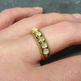 Opal Rope Row Ring worn on middle finger with nude nails, styled to highlight its cabochon opals and flashes of fire colors. A chic accessory that adds balance and clarity, ideal October birthstone jewelry gift, perfect for weddings, evening dinners, and sophisticated outings.