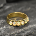 Opal Rope Row Ring featuring cabochon cut stones that highlight flashes of fire colors, offering elegance and timeless jewelry style. Known for enhancing inspiration and emotional balance, this October birthstone ring makes a meaningful gift idea. Perfect for birthdays, anniversaries, and cherished events, it can be worn to weddings, evening parties, or daily gatherings with sophistication.