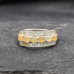 Opal Row Half Eternity Wide Ring in sterling silver featuring natural fire opals with flashes of fire colors, accented by CZ pave for a bold jewelry style. A meaningful October birthstone piece symbolizing balance and inspiration, making it a treasured gift idea. Perfect for weddings, anniversaries, cocktail events, and elegant evening occasions.