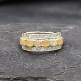 Opal Row Half Eternity Wide Ring in sterling silver featuring natural fire opals with flashes of fire colors, accented by CZ pave for a bold jewelry style. A meaningful October birthstone piece symbolizing balance and inspiration, making it a treasured gift idea. Perfect for weddings, anniversaries, cocktail events, and elegant evening occasions.