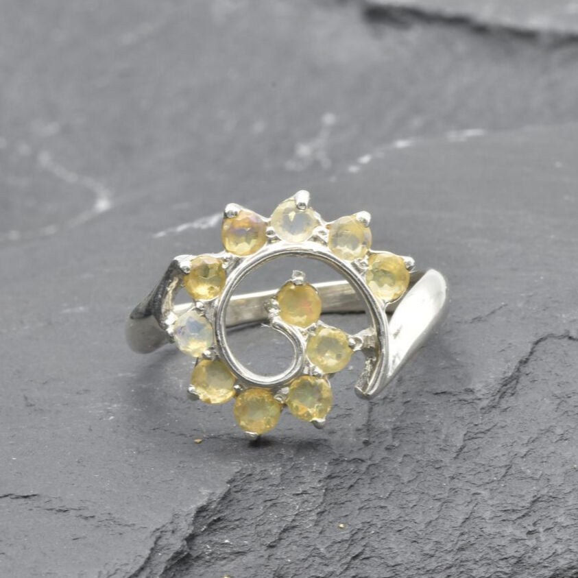 Opal Spiral Ring in sterling silver designed as a sunburst swirl statement jewelry piece offering radiant flashes of fire colors and boho charm, believed to inspire creativity and positivity, making it a thoughtful October birthstone gift idea. Perfect to wear at weddings, parties, and special occasions for a vibrant standout look.