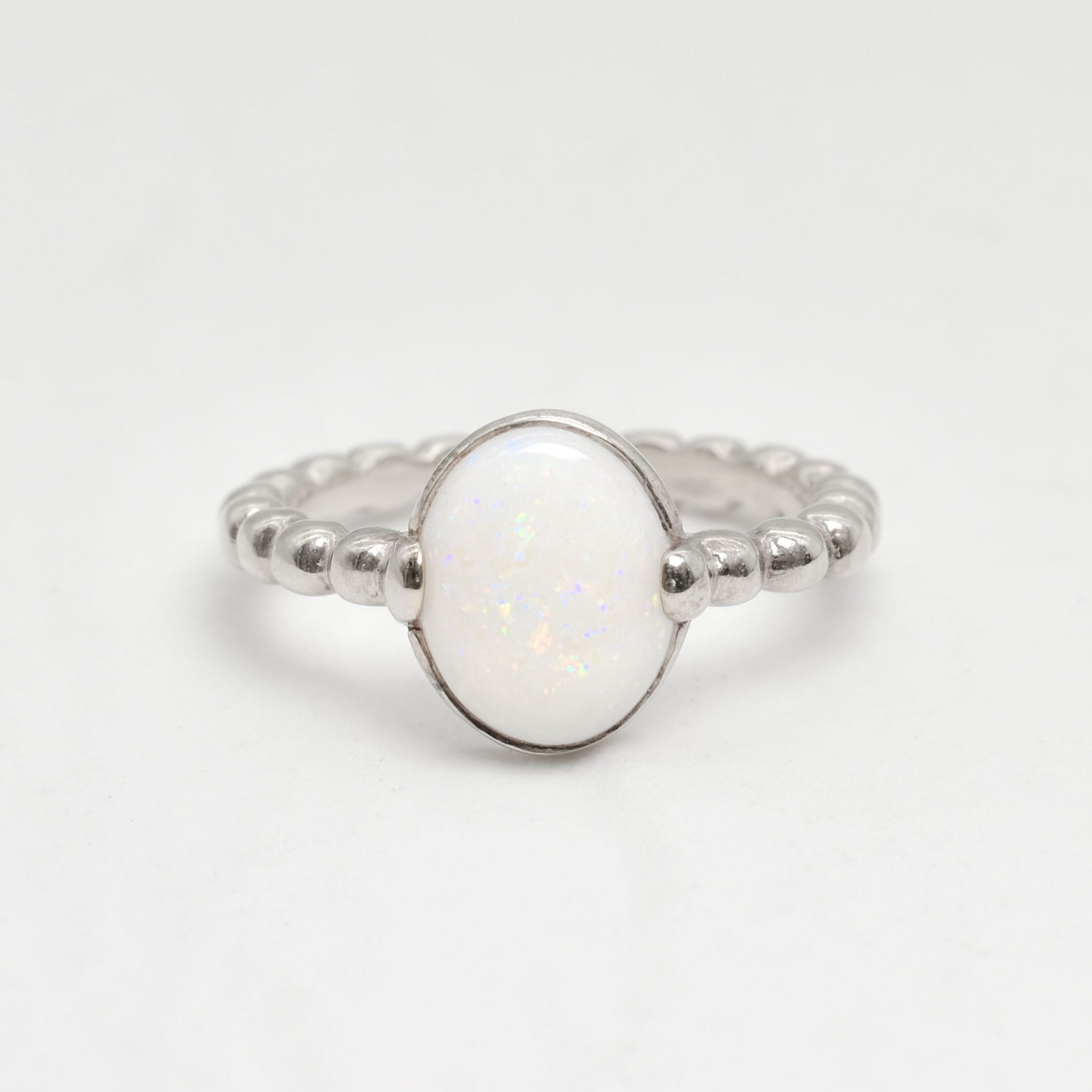 Natural Opal beaded silver ring with a smooth cabochon cut gemstone, offering a minimalist yet elegant style perfect for everyday wear. Opal, the October birthstone, is believed to inspire creativity and emotional balance, making it a meaningful gift for birthdays, anniversaries, weddings, and milestone celebrations.