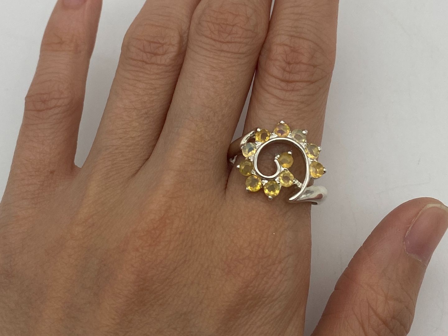 Flower Opal Ring worn on index finger with nude nails, showcasing a chic spiral design that boosts confidence and individuality, a meaningful October birthstone gift, perfect for weddings and evening gatherings.