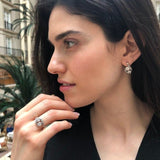Opal Two-Stone Bypass Wave Ring worn with a black V-neck dress and paired with matching earrings, showcasing the opal’s fire colors and wave bypass design accented by CZ pave. A sophisticated October birthstone accessory, ideal for gala dinners, cocktail events, and festive celebrations.