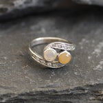 Two-Stone Opal Bypass Wave Ring in sterling silver showcasing cabochon-cut opals with flashes of fire colors and CZ pave accents for an elegant jewelry style. Known for enhancing emotional clarity and balance, this October birthstone ring makes a thoughtful and meaningful gift idea. Perfect for anniversaries, weddings, cocktail events, and celebratory occasions where sophistication shines.