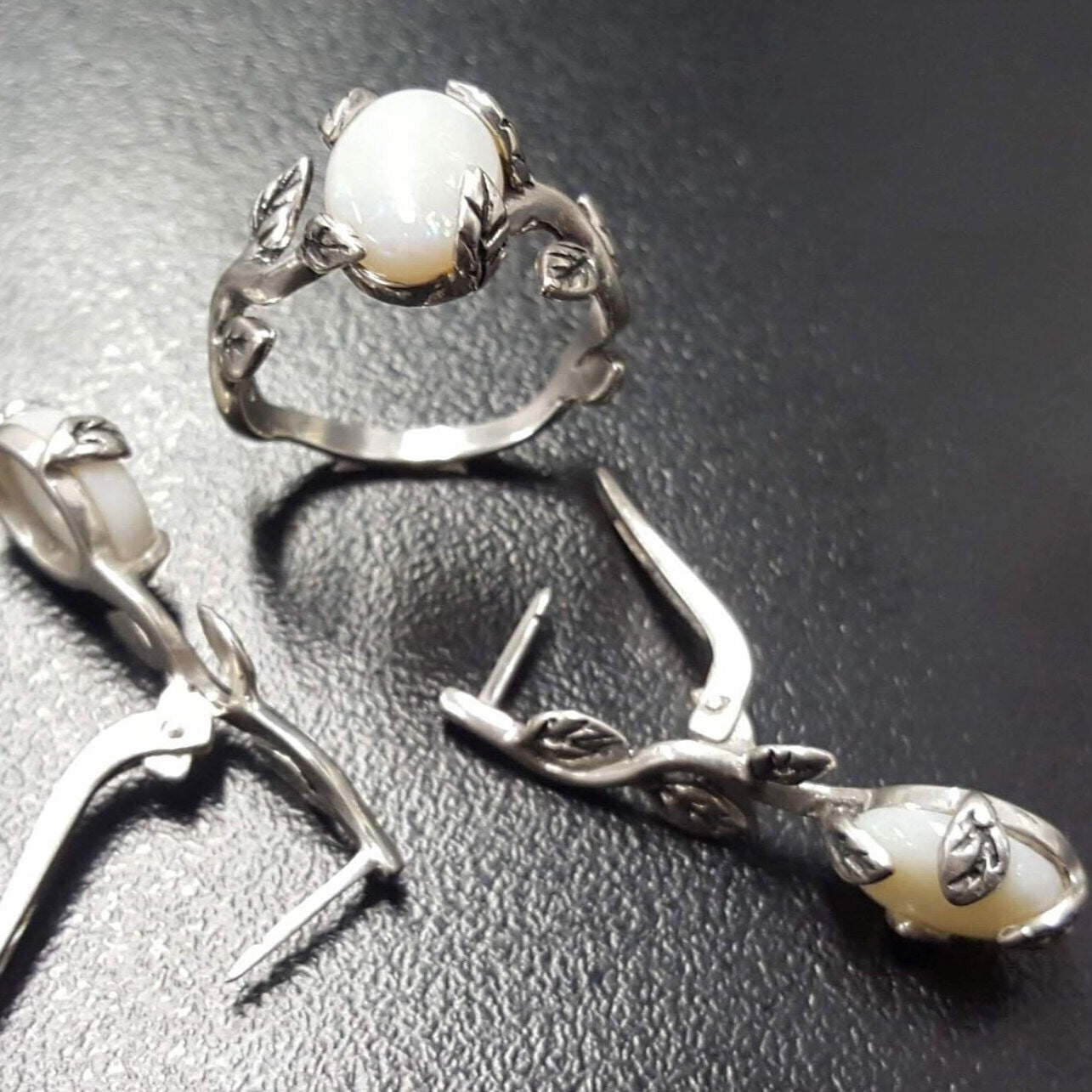 White Opal cabochon vine and leaf ring crafted in solid 925 sterling silver, featuring a nature-inspired design with flashes of fire colors. The durable vine-style band offers elegance and uniqueness while remaining comfortable for daily wear. As the October Birthstone, White Opal makes a thoughtful gift for birthdays, anniversaries, and nature lovers. Perfect to wear at weddings, outdoor celebrations, and festive gatherings.
