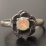 Vintage Fire Opal flower ring with a rose inspired artisan design in silver. The daisy style petals frame a round opal center for a floral and feminine look. Opal is believed to bring hope, creativity and emotional balance, making it a meaningful October birthstone gift. Perfect for weddings, anniversaries, special celebrations and romantic events.