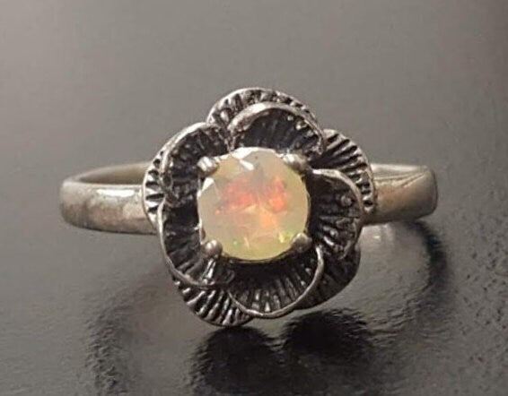 Vintage Fire Opal flower ring with a rose inspired artisan design in silver. The daisy style petals frame a round opal center for a floral and feminine look. Opal is believed to bring hope, creativity and emotional balance, making it a meaningful October birthstone gift. Perfect for weddings, anniversaries, special celebrations and romantic events.