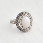 Australian Opal statement ring in silver with halo of CZ diamonds, featuring an oval cabochon gemstone, ideal for glamorous statement style, believed to inspire creativity and love, a perfect October birthstone gift for anniversaries, engagements, and elegant celebrations.