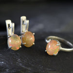 Ethiopian Fire Opal Solitaire Ring in sterling silver with a cabochon cut oval stone showing flashes of fire colors. Opal is linked to creativity, inspiration, and emotional balance, making it a meaningful October birthstone gift. A thoughtful choice for birthdays, anniversaries, promise rings, or engagements. Suitable for daily wear, weddings, and classic elegant occasions.
